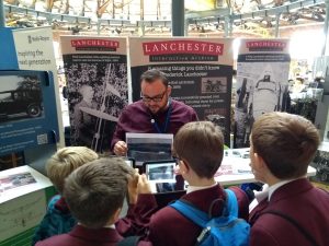 An LIA team member talks to a group of schoolchildren.